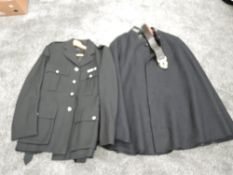 A Police Officers Jacket wiith buttons and a Police Officers Cape with metal numbers on collar