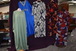A collection of 60s and 70s dresses, mixed styles and sizes, lots of bright patterns.