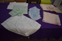 A collection of vintage table linen including damask in various colours.