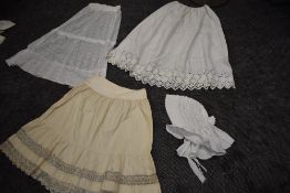 A collection of antique petticoats, a skirt and a bonnet.