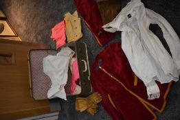 A vintage suitcase with a selection of mixed vintage clothing such as corduroy breeches and similar,