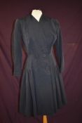 A vintage navy blue dress coat by Connei models for Harvey Nichols of Knightsbridge.