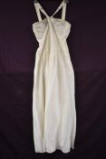 A 1940s full length cream evening dress having silver beadwork to bodice, unusual straps starting