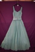 An emerald green 1950s dress having full skirt with hoop.
