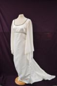 A vintage 1970s white wedding or occasion dress having angel sleeves and silver beaded detailing