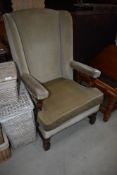 A traditonal oak frame and green dralon wing back armchair, good heavy quality