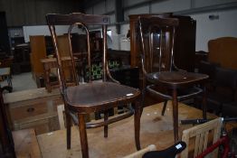 A pair of traditional bentwood chairs having ply seats, one with foliate detail
