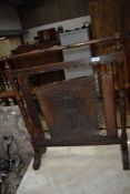 An early 20th Century firescreen having turned oak frame and tooled leather panel and strap work