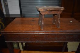 A 19th Century oak foldover tea table and a rustic stool of small proportions