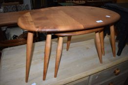 A stripped Ercol pebble style nest of three tables