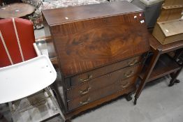 An early 20th Century mahogany bureau on cabriole legs and ball and claw feet