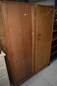 A pair of vintage golden oak 'left and right' wardrobes, possibly Gomme