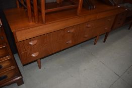 A vintage teak sideboard having stylised wooden handles, width approx. 135cm