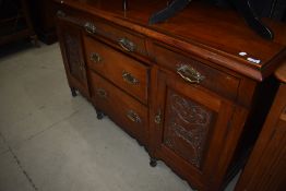 A Victorian mahogany sideboard having carved panel doors and brass handles