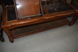 A modern glass top coffee table in the classical style having canework undertier, approx 132 x 57cm