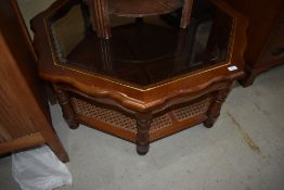 A modern stained frame octagonal coffee table having glass top and canework undertier