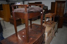 An early 20th Century mahogany frame piano stool of plain form with arm rests and square tapered