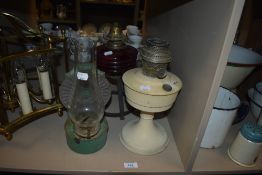 A trio of vintage and antique oil lamps,including green wall mounted example with chimney, and