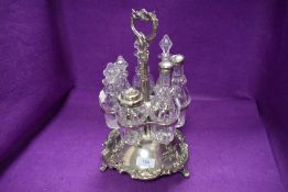 A Victorian silver plated rotating condiment centre piece, having floral detailing and handle on
