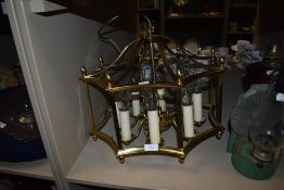 A brass framed centre light having candle effect bulb holders.