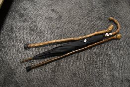 Two walking canes and a vintage bamboo handle umbrella