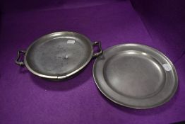 A pewter dinner plate and a similar pewter warming plate