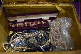 A seagrass sewing box containing a selection of costume jewellery including simulated pearls and