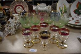 A collection of vintage coloured glasses,some etched and others with gilt details.