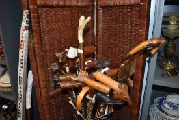A large collection of walking sticks and canes including animal design handles