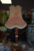 A vintage turned teak desk lamp having mid century chiffon shade.