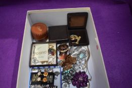 A selection of costume jewellery including pendants, brooches, clip earrings, enamelled coin