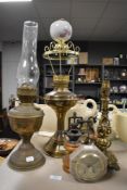 Two brass bodied oil burning lamps, a coffee mill and a brass lamp base