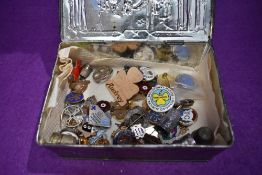 A vintage Riley's toffee tin containing a selection of badges and pins including several Girl