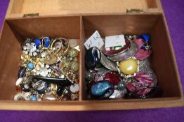 A treen box containing a selection of earrings of various forms