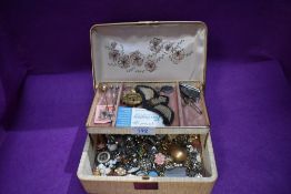 A vintage jewellery box containing a small selection of costume jewellery earrings, bar brooches,