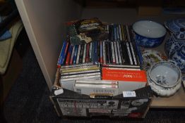 A box of mixed compact discs.