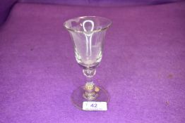 A deep bowl wine glass with two knops to stem.