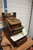 A vintage shop keepers till by National with a painted wood effect cover