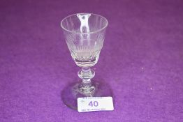 A small wine glass with central knop to stem and decoration to bowl.