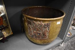 An antique brass worked fire basket or similar with a cooper coat of arms or family crest motif also