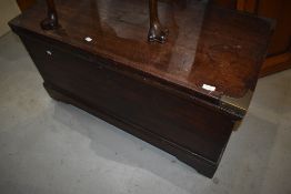 A traditional stained frame bedding chest having brass corners, on castors