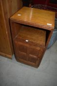 A vintage golden oak bedside cabinet having panelled door, possibly Arts and Crafts