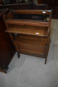 An early 20th Century oak bookshelf having interesting design with trough top, pull out shelf and