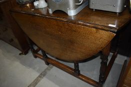 A traditional oak gateleg dining table having turned legs