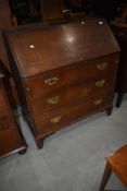 A Georgian oak bureau having semi fitted interior, three long drawers to base on bracket feet,