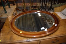 A stained frame oval wall mirror