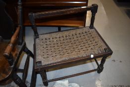 A traditional strung stool having rail back