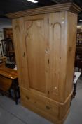 A stripped pine double wardrobe having drawer base, width approx. 118cm