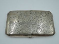 A large silver double opening cigarette case having scroll decoration with monogrammed cartouche and