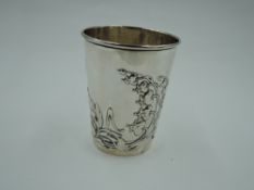 A white metal beaker having Art Nouveau style floral repousse decoration and gilt interior,